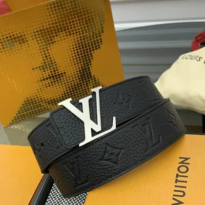 Black leather belt with a matte buckle coiled on a printed box