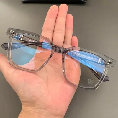 Hand holding clear-framed glasses with light blue tinted lenses