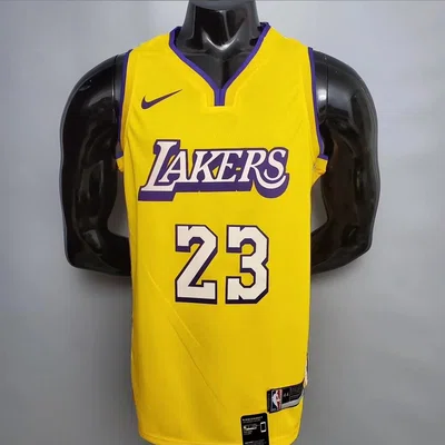 Gold basketball jersey with purple number 23 trim on a black mannequin